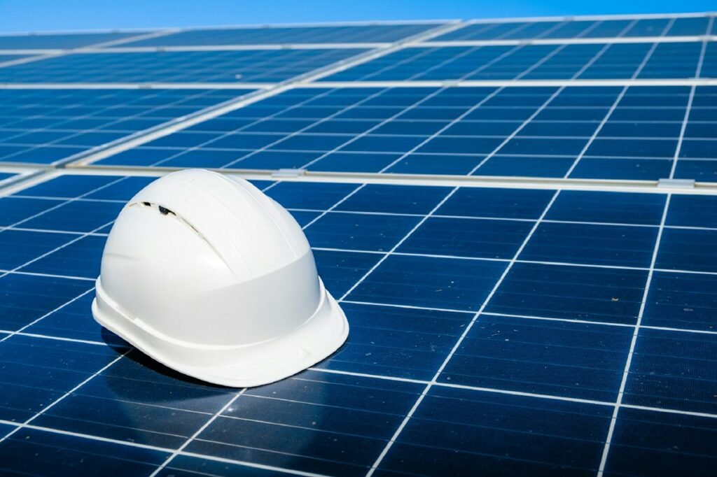 Solar installation documents and an orange safety helmet on photovoltaic panels